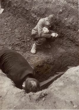 A Polish boy, Michael Kallaur, weeps while helping his father bury the body of his grandmother